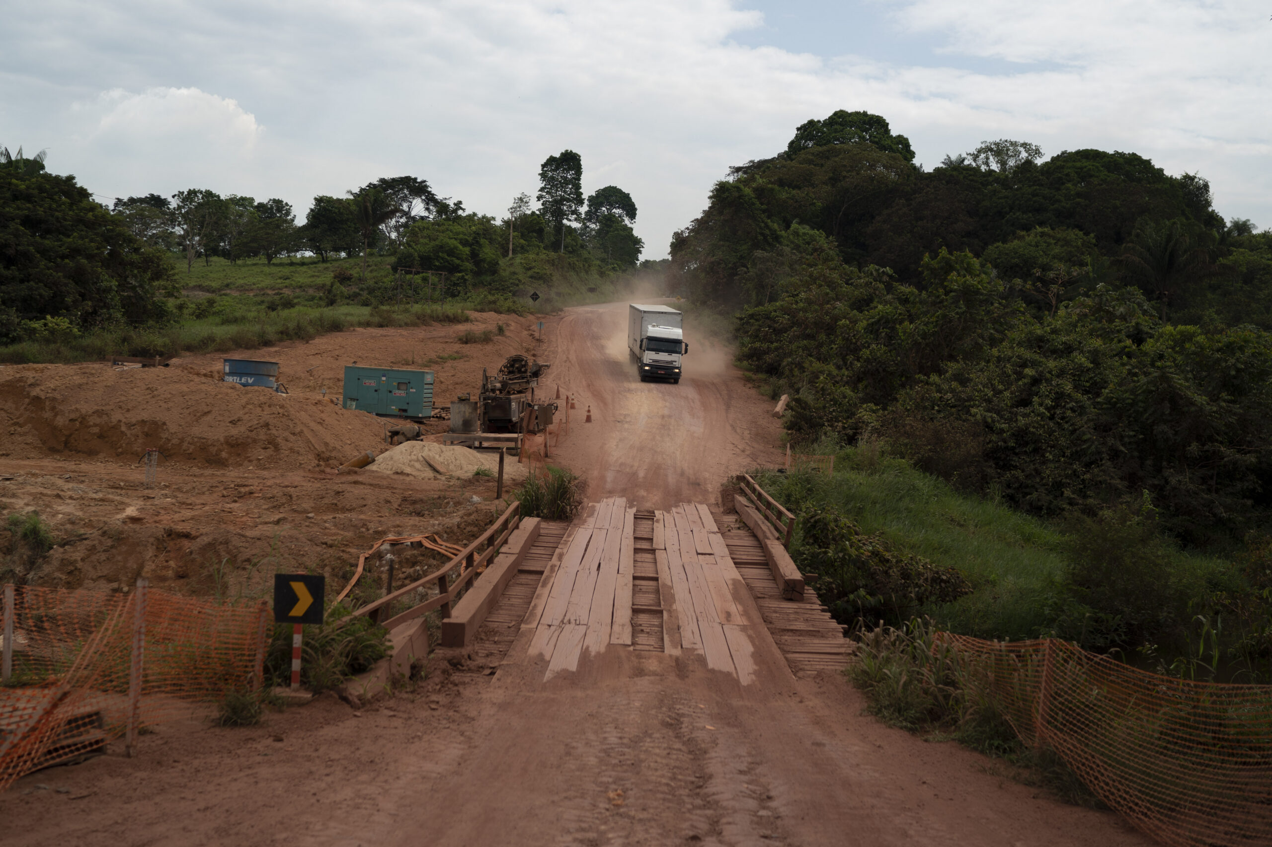 In this Nov. 26, 2019 photo, a truck drives on the road in Ruropolis, Para state, Brazil. From Ruropolis, the Trans-Amazon and BR-163 run jointly westward over a bumpy 70 miles before splitting at a little roundabout. During corn and soy harvests, 2,600 trucks pass through each day to and from the nearby Tapajos river. Image by AP Photo/Leo Correa.