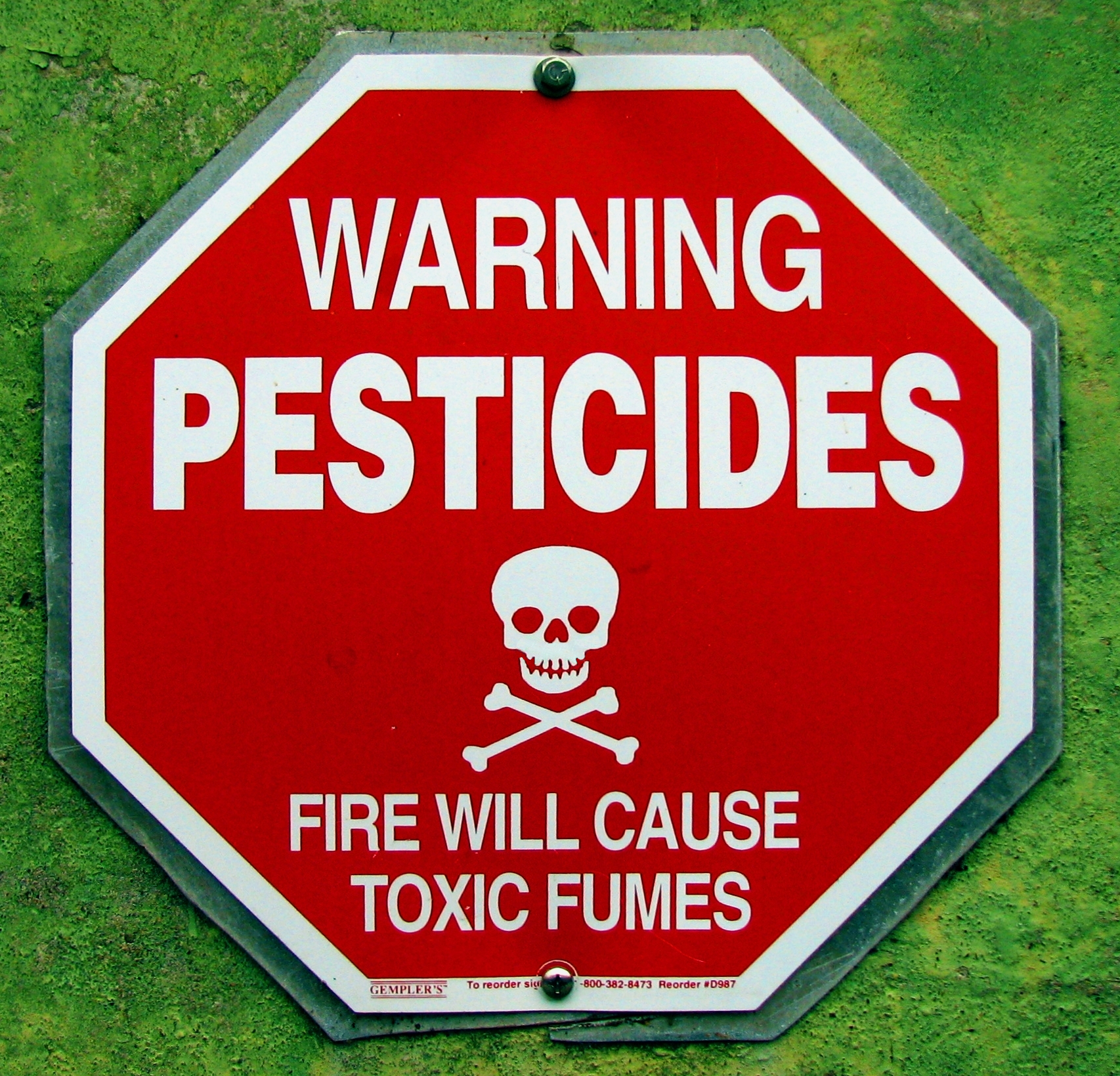 A sign warning about potential pesticide exposure.