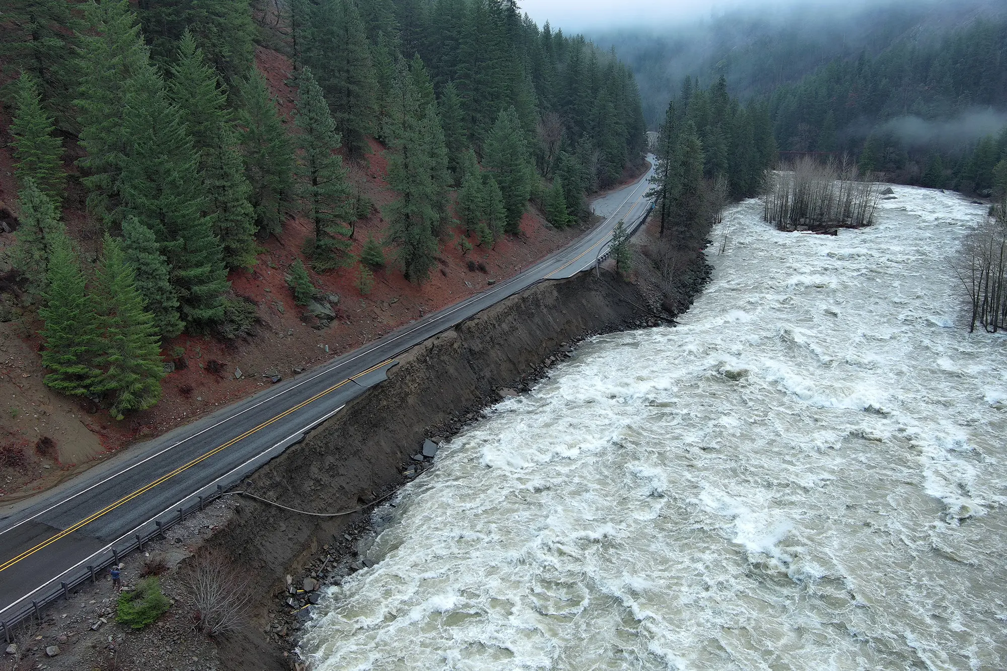 A rushing river has washed away a large section of highway.