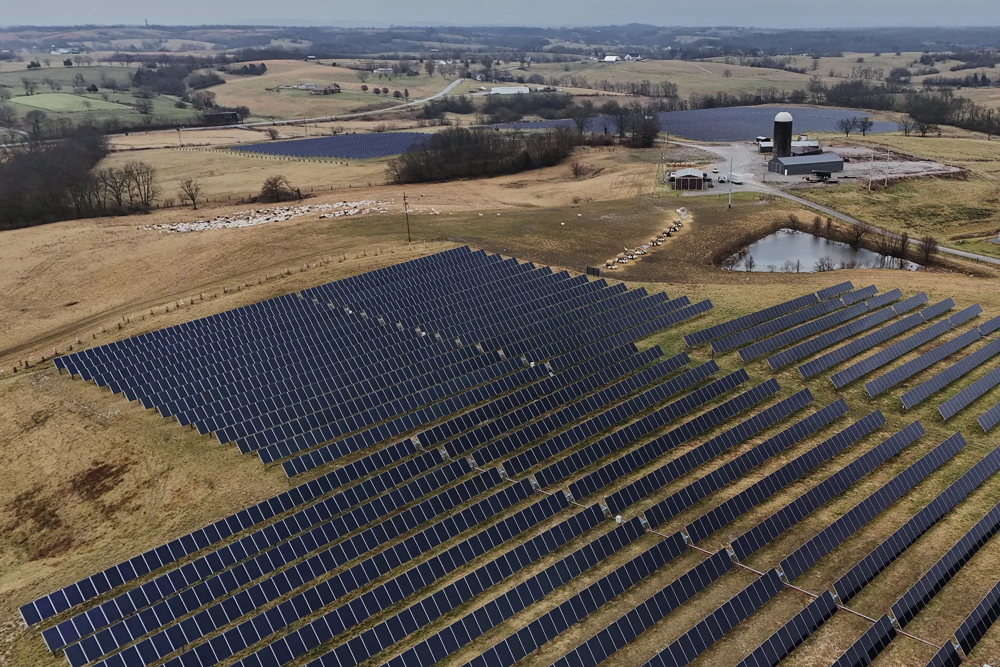 An aerial photograph of a large array of solar panels surrounded by farmland.