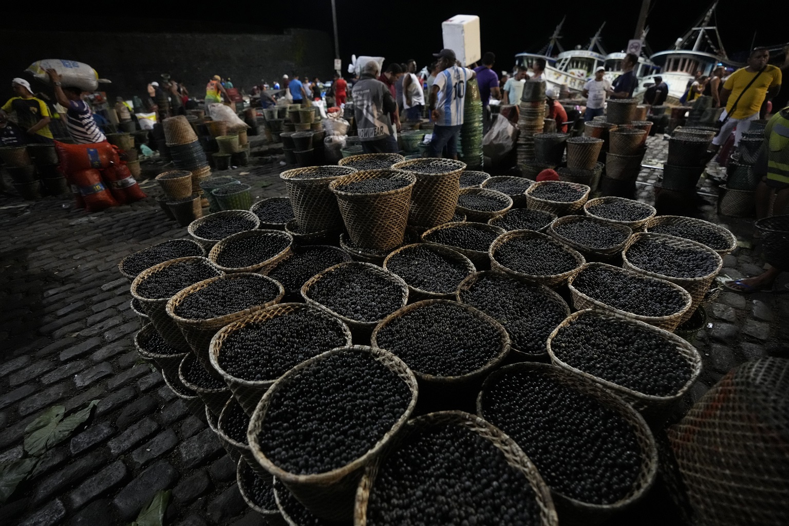 Baskets of açaí are for sale at the Açaí Fair at the Ver o Peso market in Belem, Brazil, Monday, Aug. 7, 2023. Among leaders and advocates of the Amazon rainforest region, there's hope for bioeconomy, a term that refers to people making a living from the forest without cutting it down. Examples include açaí fruits, Pirarucu fish and rubber tapping.