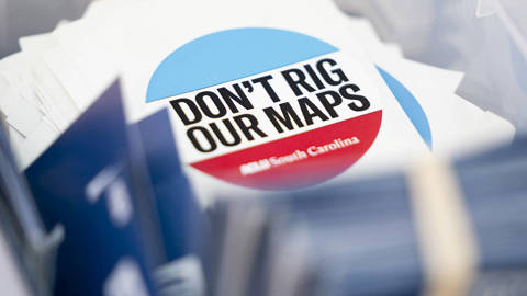 A pile of ACLU South Carolina stickers reading “Don’t rig our maps,” shown during a voting rights and redistricting protest.
