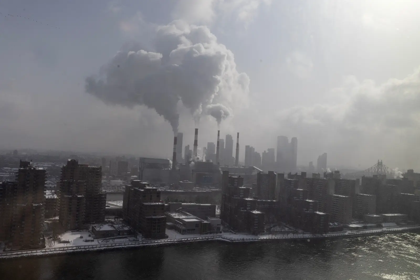 Steam rises from the smokestacks of the Ravenswood Generating Station, the largest power plant in New York City. The state has struggled to build out enough clean power to replace its natural gas power plants.