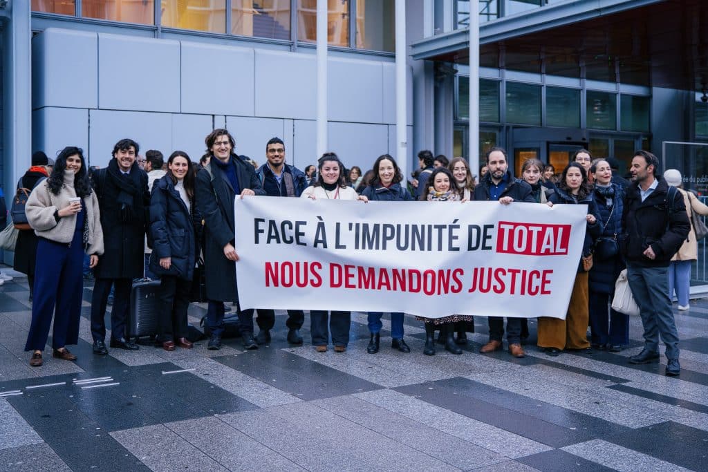 Activists stand in front of the Paris Court of Justice on February 19 as hearings for a climate case against TotalEnergies begin.