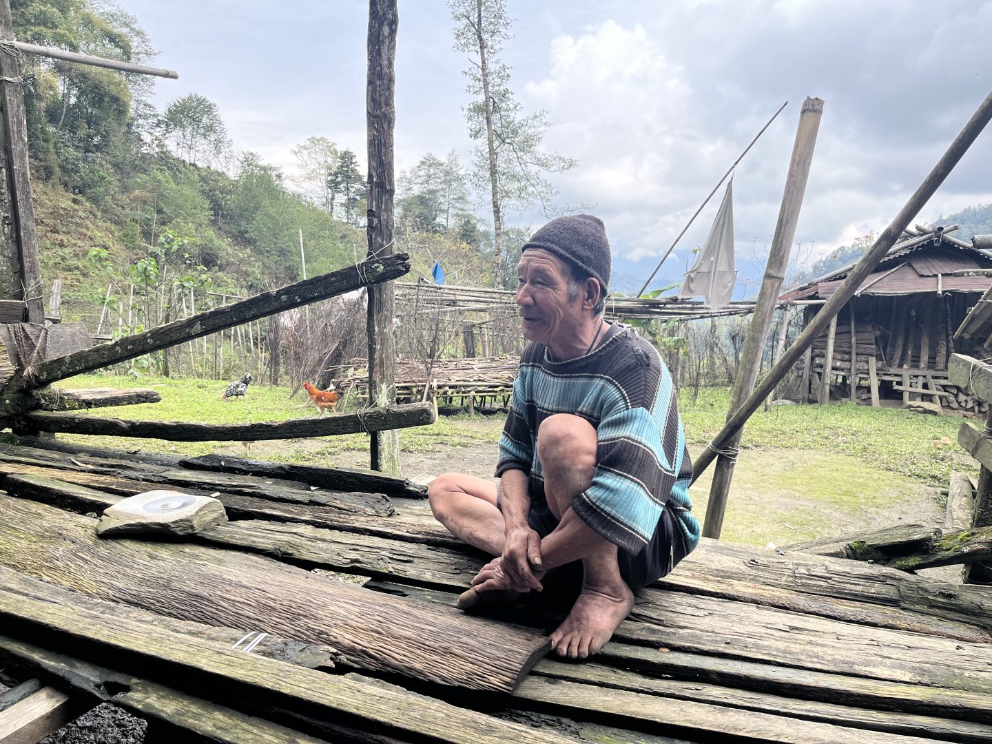 An elderly man sits on a wooden deck in the village of Phop,in Arunachal Pradesh, India